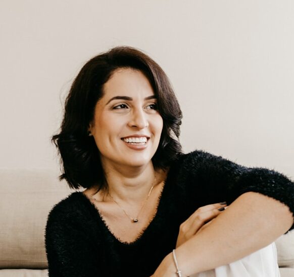 woman in black long sleeve shirt sitting on white couch